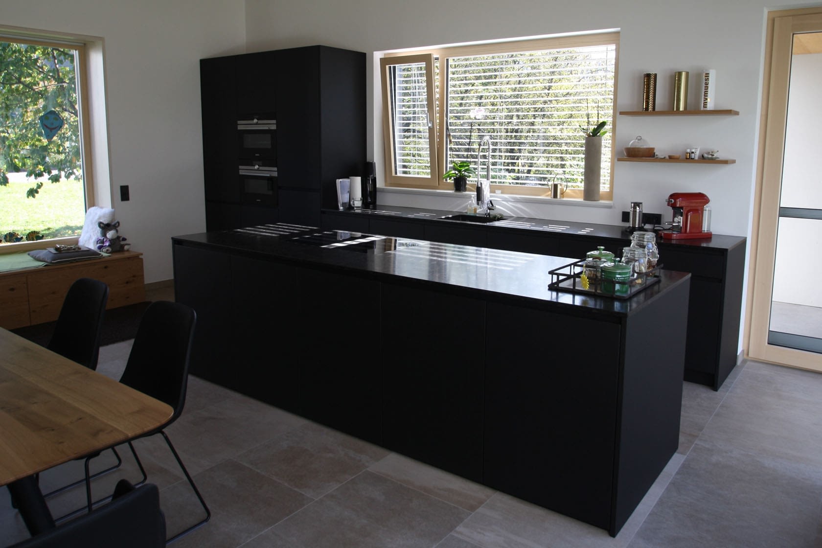 große Kücheninsel Fenix Front mit schwarzer Granit Arbeitsplatte